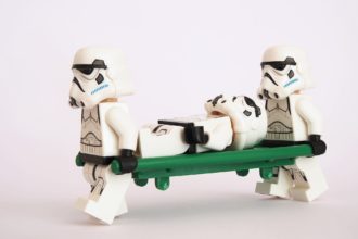 Deux stormtroopers en portent un troisième sur un brancard.